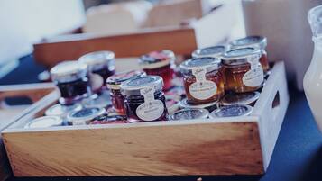 A wooden box containing various jars of marmalade.