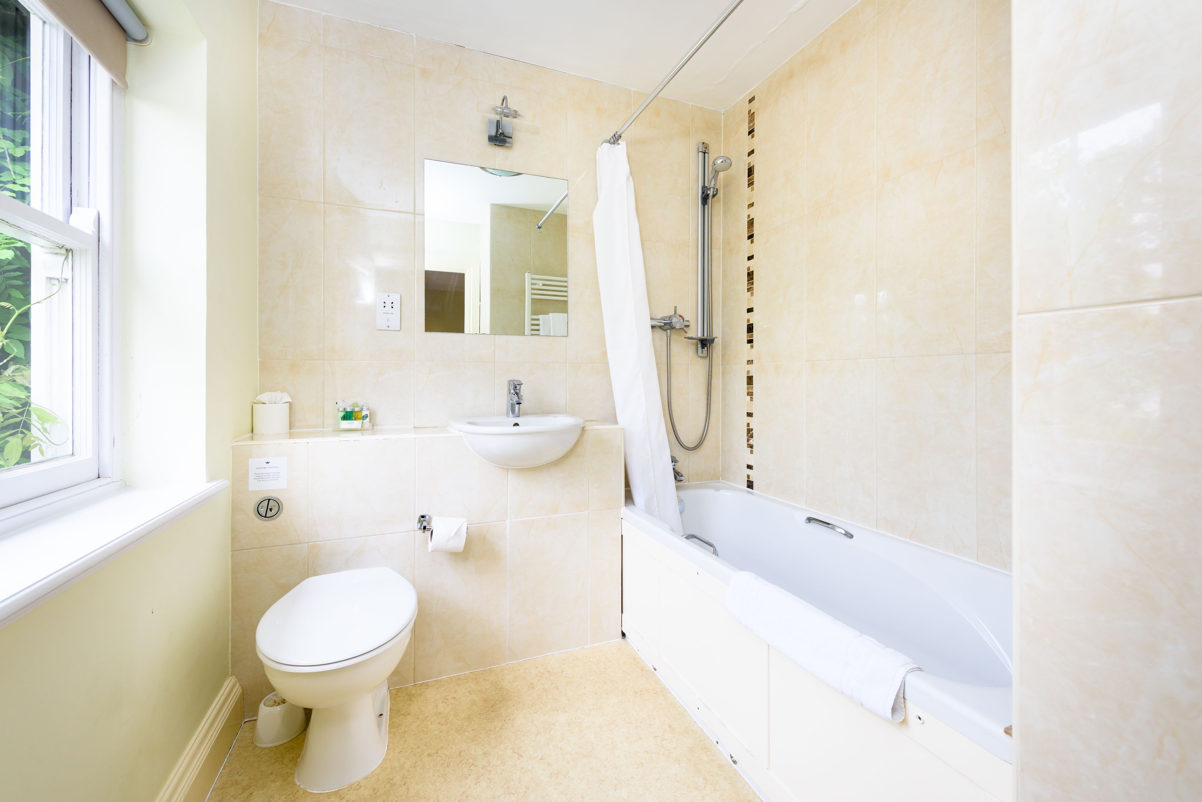 A bathroom with a toilet, sink, and bathtub.