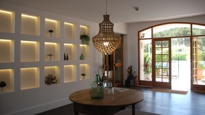 Un interior moderno con una mesa redonda de madera, iluminación empotrada y un amplio ventanal arqueado.