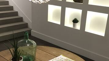 A wooden table with a map and a brochure, a green glass bottle, and a potted plant.