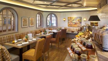 Un restaurante con mesas de madera, cabinas acolchadas y una variedad de alimentos expuestos en la barra.