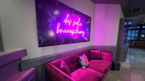 A modern lobby with a vibrant purple sofa and a neon sign reading "das seel braunchwig". - Das Seela Braunschweig (Braunschweig)
