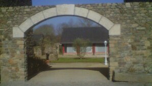Un arco de piedra que conduce a un edificio con una puerta roja.