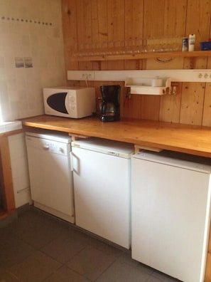 A compact kitchen with a microwave, coffee maker, and a small refrigerator. - Manoir De Kermodest (Quemper-Guezennec)