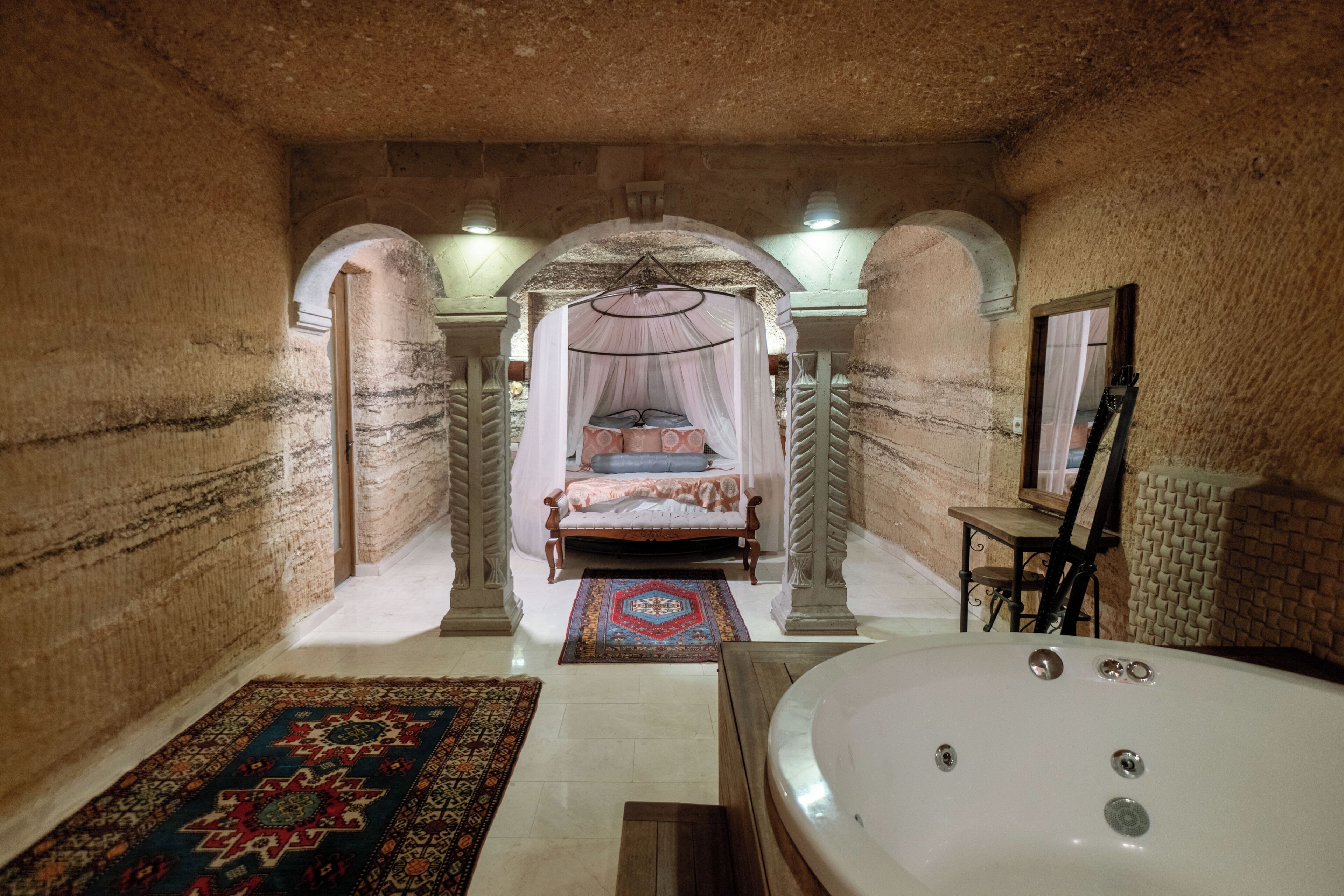 A room with a bed, a bathtub, and a chair.