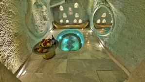 Interior de una cueva de hielo con una piscina central, zonas de estar y un frutero.