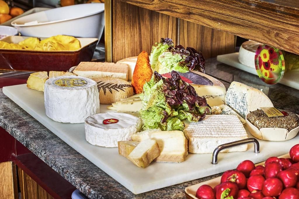 A variety of cheeses and fruits on a wooden table.