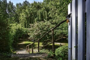 A wooden staircase leading up to a building, surrounded by lush greenery and trees.