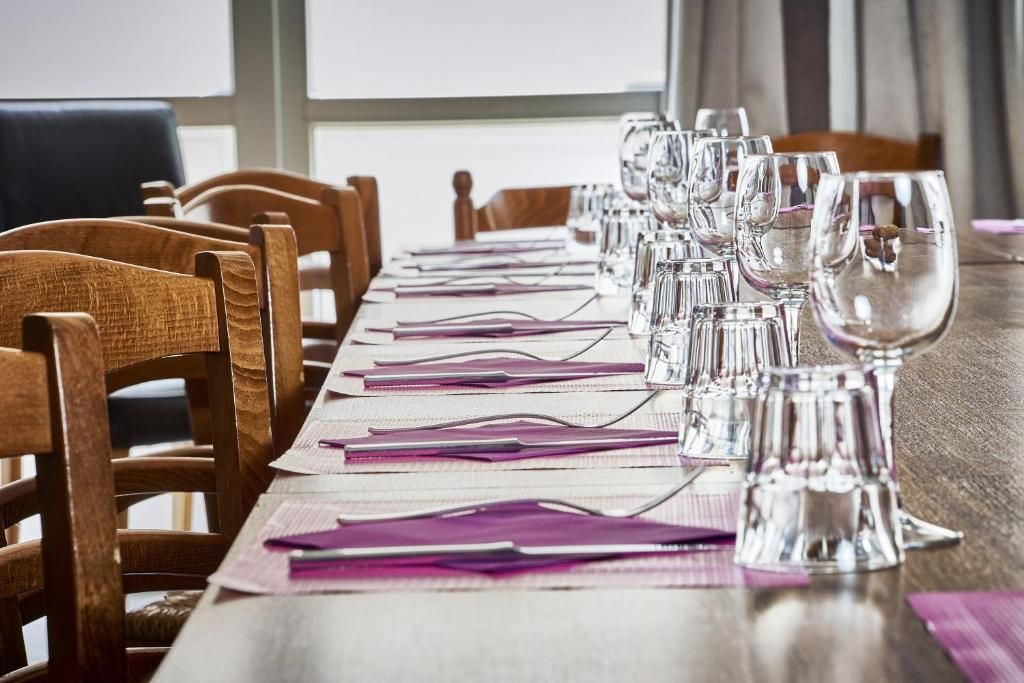 A conference table set with chairs, glasses, and documents.
