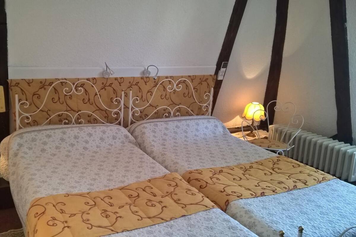 A double bed with a patterned headboard and two bedside lamps.