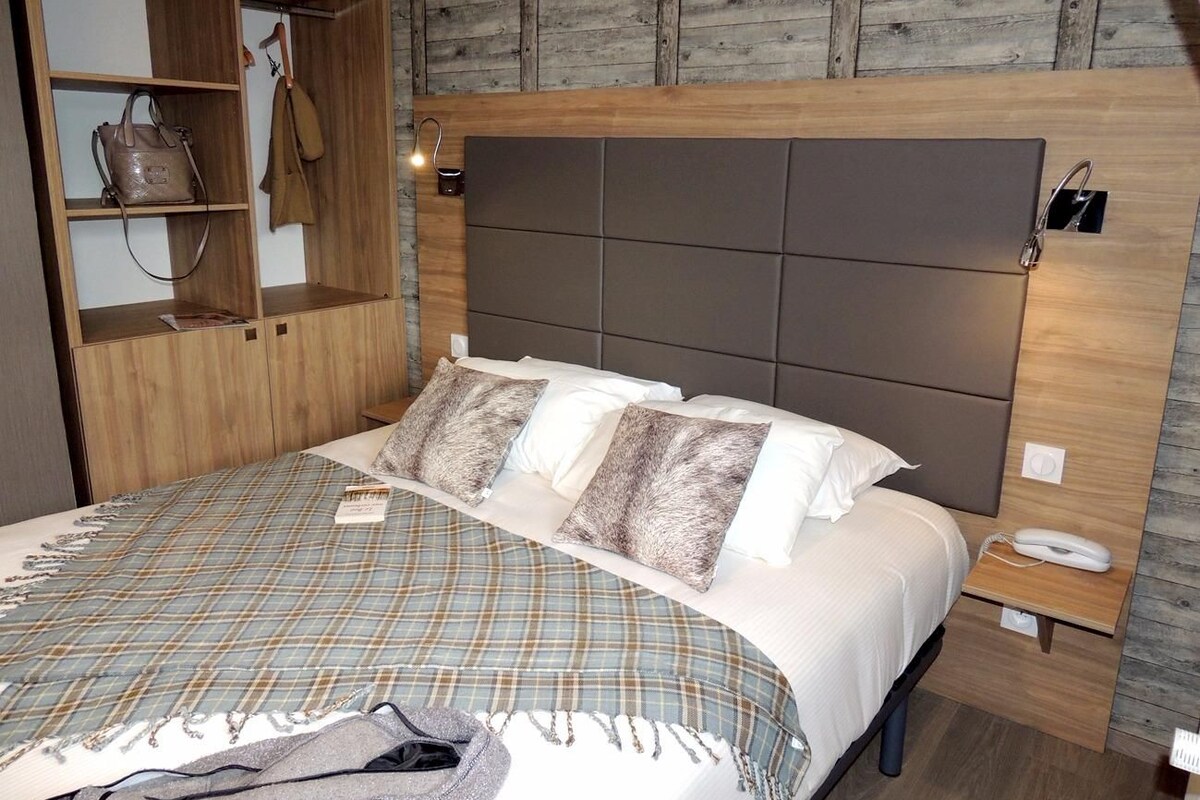 Un dormitorio con cama, armario, mesita de noche y lámpara de pared.