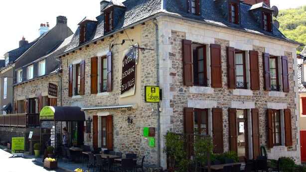 Un edificio de piedra con un letrero que indica un restaurante y un bar.