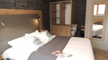 A modern bedroom with a large bed, wooden headboard, and a walk-in closet.