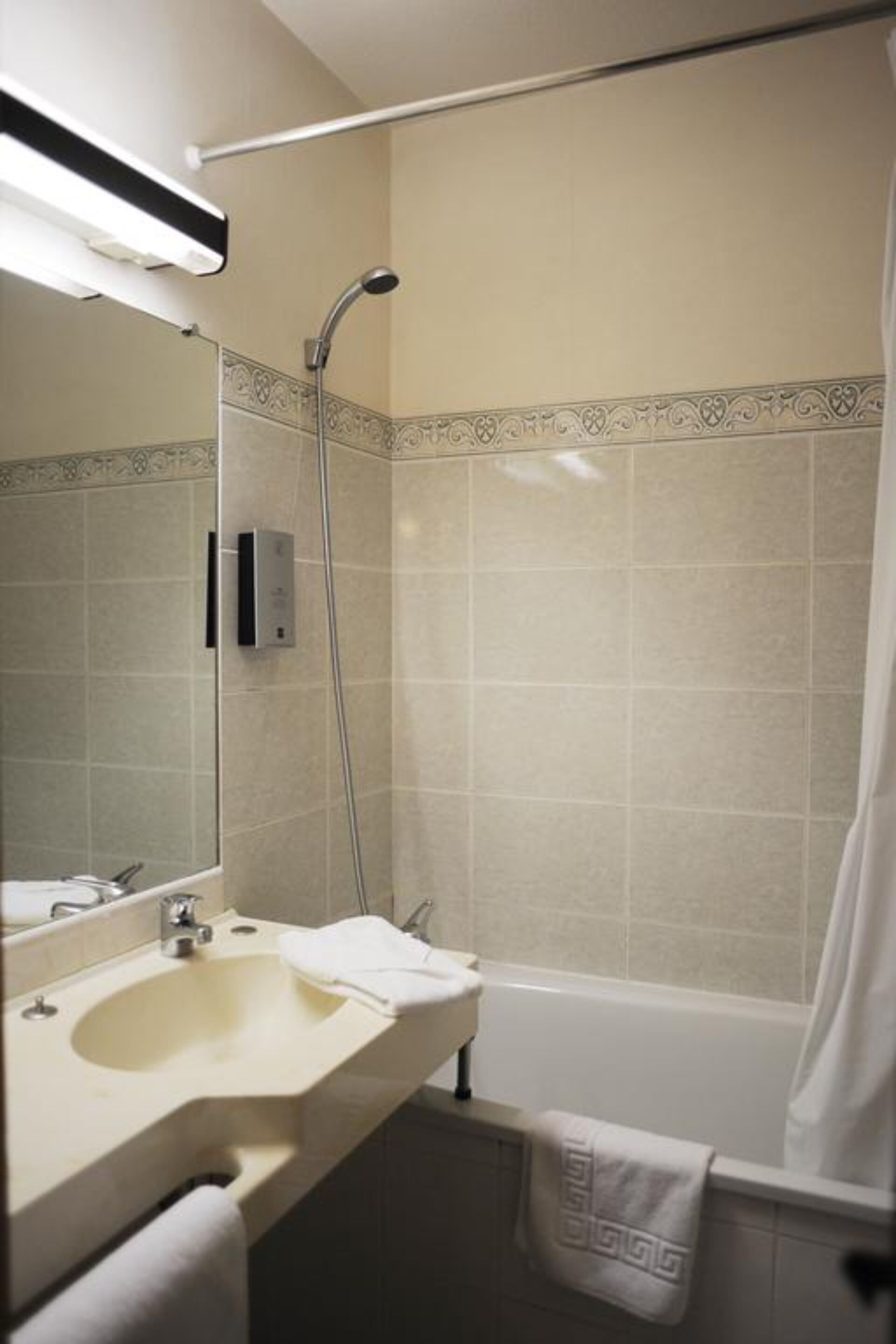 A bathroom with a sink, mirror, shower, and bathtub.