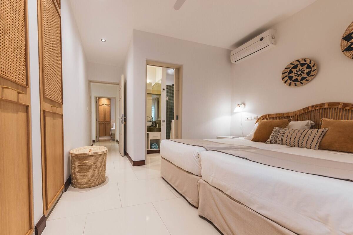 Une chambre d’hôtel avec un grand lit, une petite table ronde et un climatiseur fixé au mur.