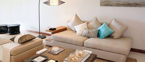 Una sala de estar con sofá, mesa de centro y lámpara de pie.