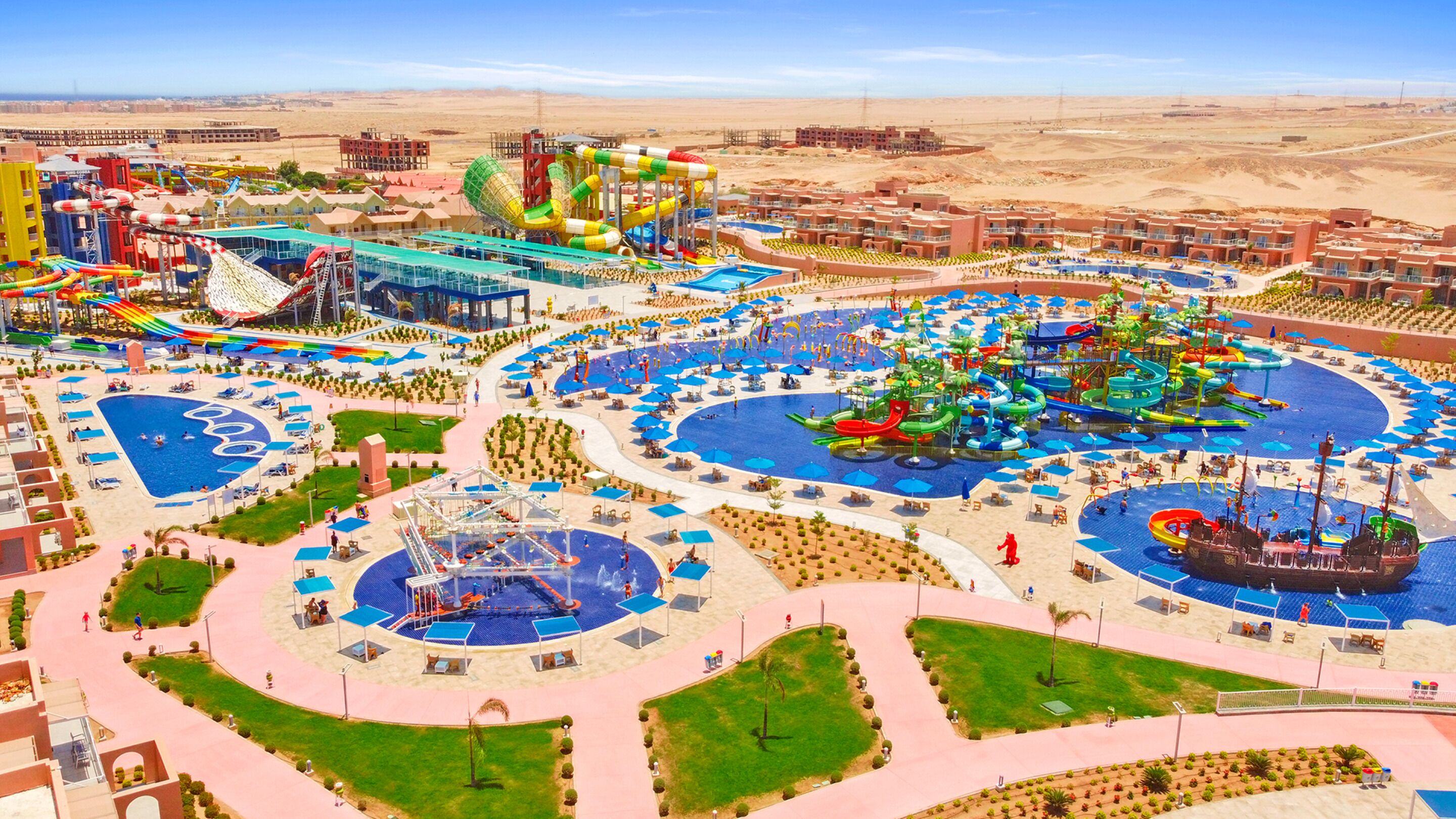 A resort with multiple swimming pools, water slides, and a large ship replica.