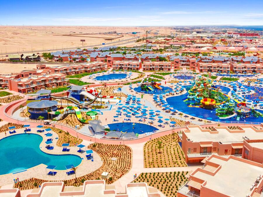 A resort with multiple swimming pools, water slides, and a large central pool.