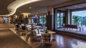 A spacious lobby with modern seating, large windows offering views of greenery, and a curved ceiling design. - Kiki Shiretoko Natural Resort (Shari)