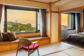 A hotel room with a large window, a bed, a chair, and a view of a landscape. - Kiki Shiretoko Natural Resort (Shari)