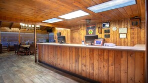 A wooden interior with a reception desk, chairs, and a clock on the wall. - Travelodge by Wyndham Hawthorne (Hawthorne)