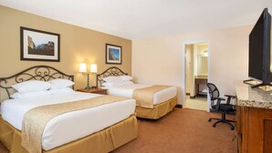 A hotel room with two beds, a desk, a chair, and a television. - Travelodge by Wyndham Hawthorne (Hawthorne)