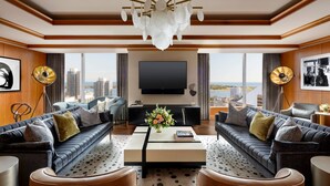 A modern living room with a large flat-screen TV, two sofas, a coffee table, and a view of the city. - The Ritz-Carlton, Toronto (Toronto)