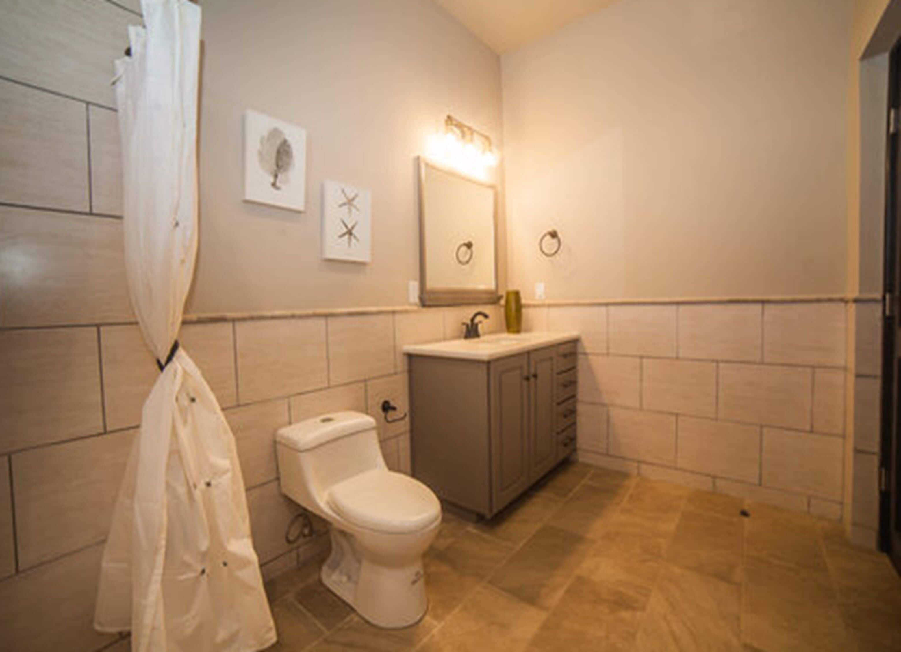A bathroom with a toilet, sink, and a shower curtain.
