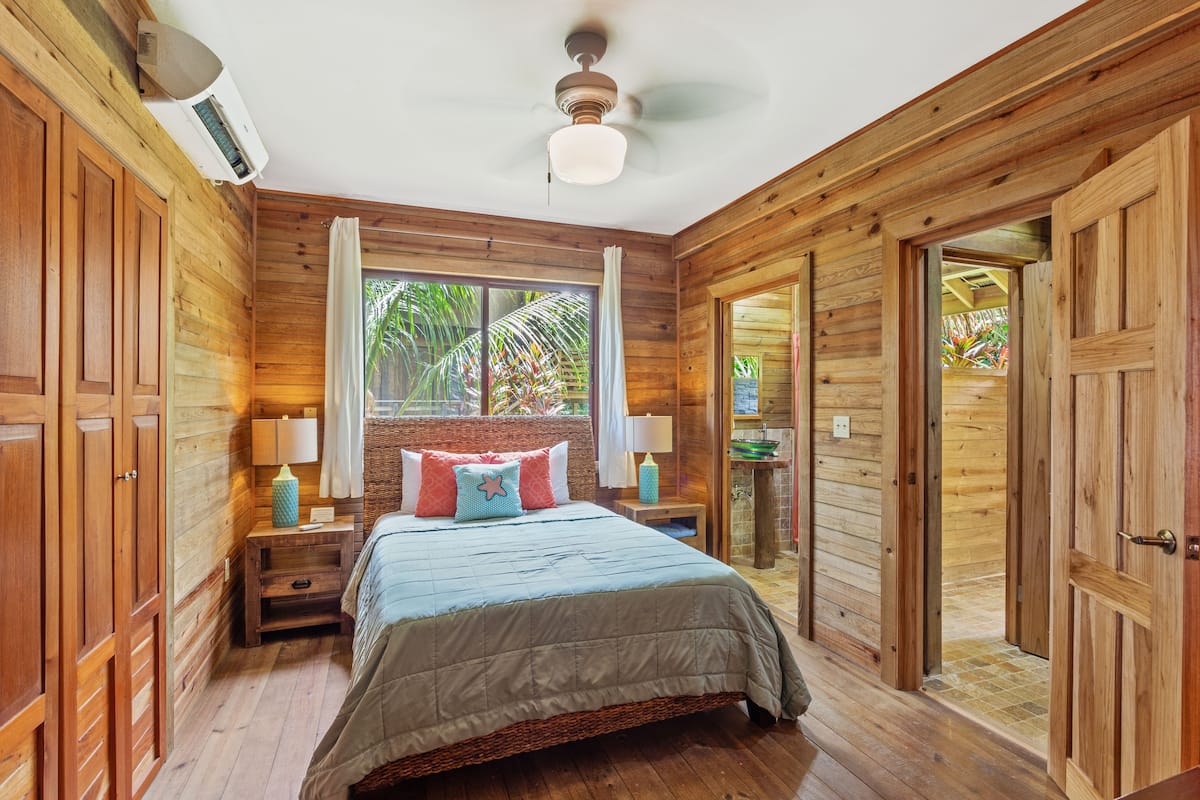 Une pièce en bois avec un lit, une fenêtre et une porte.
