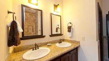 A bathroom with two sinks, a mirror, and towel racks.