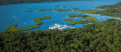 An aerial view of a coastal area with numerous small islands and a dense forested coastline.