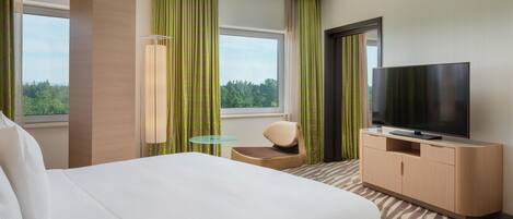 A hotel room with a bed, a television, a desk, and a chair.