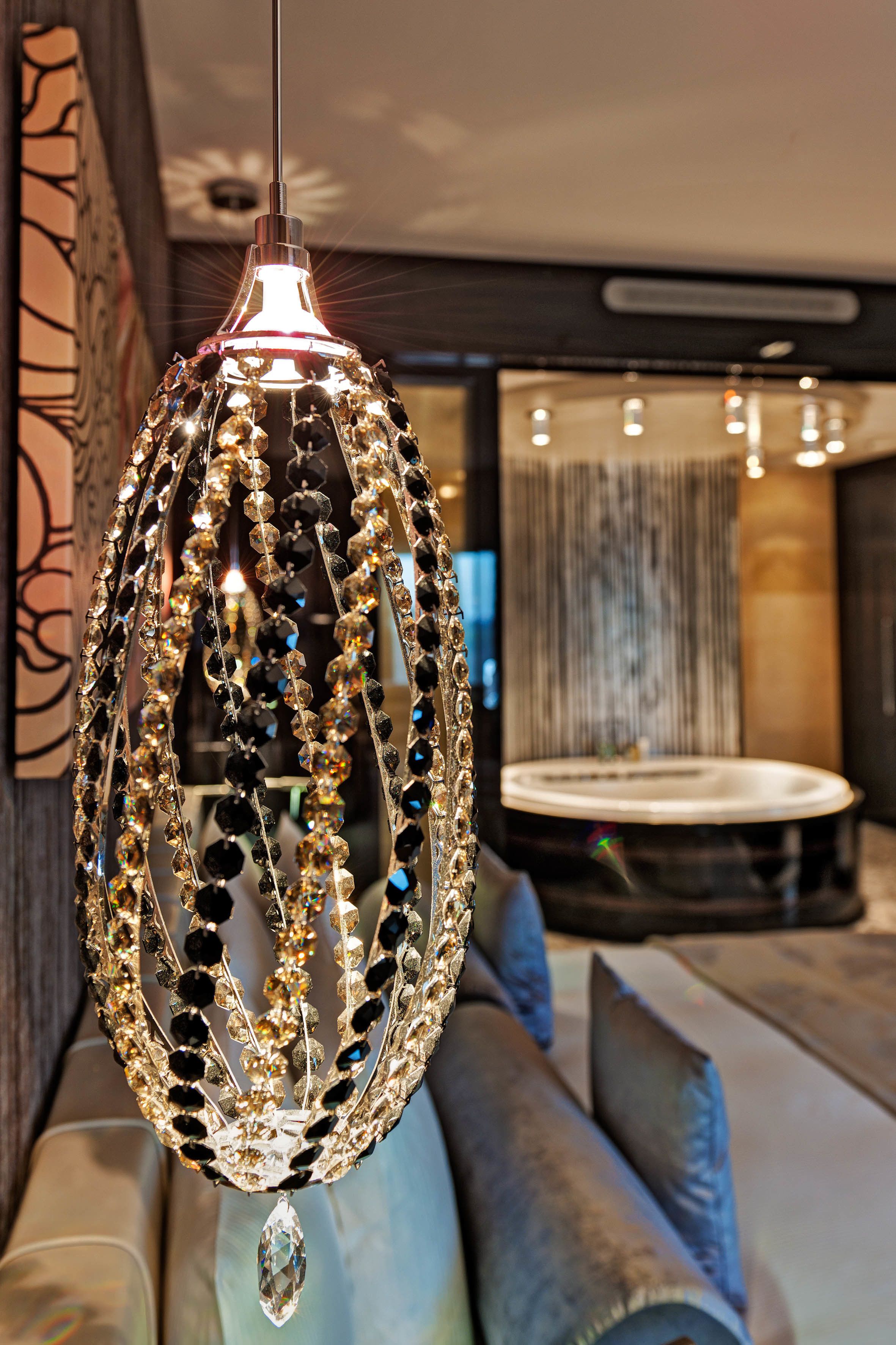 A chandelier with multiple strands of beads and a central teardrop-shaped crystal hanging from the ceiling.