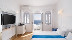 Une chambre d’hôtel moderne équipée d’un lit, d’une télévision et d’un balcon avec vue.
