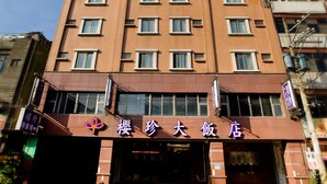 Een meerlaags hotel met een opvallende ingang en borden.