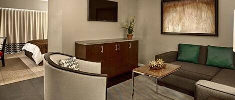 Una sala de estar moderna con un sofá, una mesa de centro, un mueble aparador y una silla.