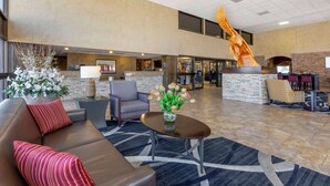 A spacious lobby with a modern design, featuring a reception desk, seating area, and a large decorative sculpture. - Best Western Plus Raton Hotel (Raton)
