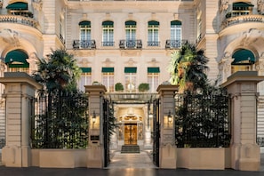 A grand entrance with a double door, a staircase, and a balcony with railings.