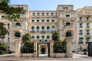 A grand building with multiple balconies, a central entrance, and classical architectural details.