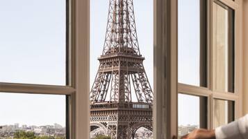 Vista de la Torre Eiffel a través de una ventana con barandilla de balcón.