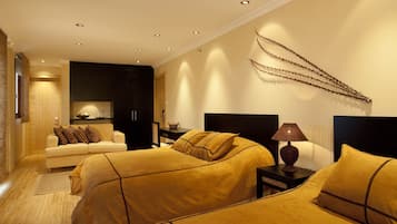 Quarto de hotel com duas camas, um sofá, uma luminária e um objeto decorativo na parede.