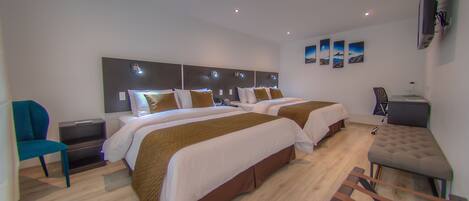 A hotel room with two beds, a desk, a chair, and a TV.