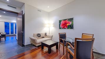 A modern living room with a sofa, coffee table, and dining set.