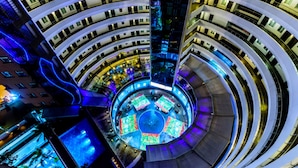 A multi-level hotel with a central atrium featuring a circular seating area and multiple balconies.