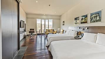Una habitación de hotel con dos camas, un escritorio, una silla y un televisor.