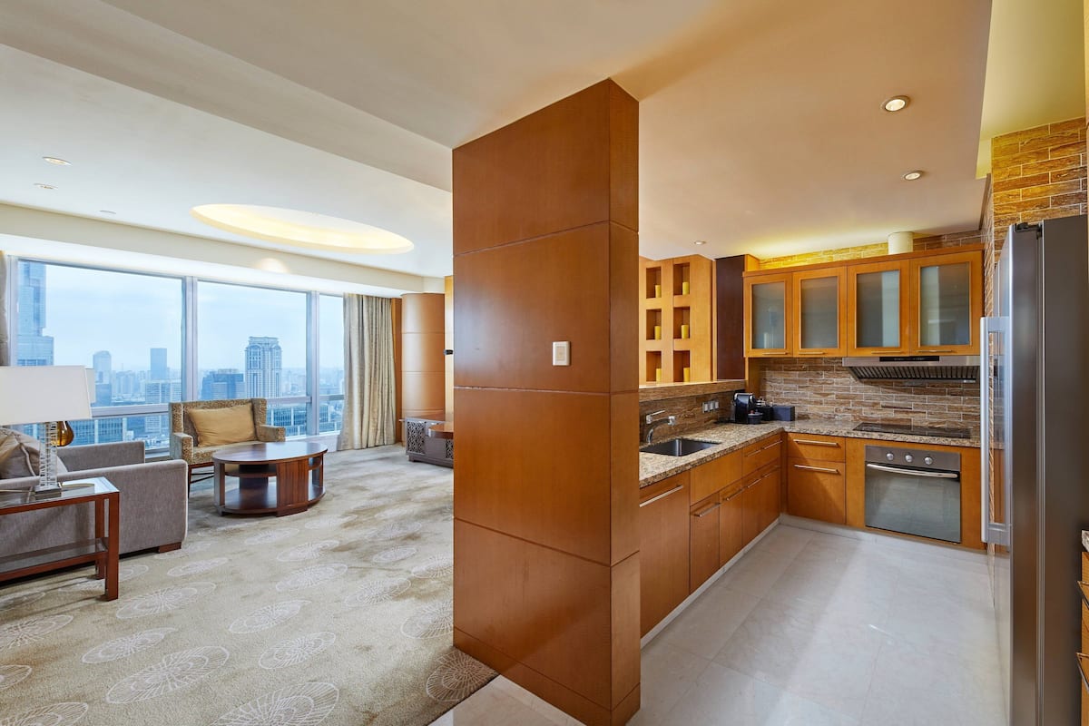 A modern kitchen with a city view, wooden cabinets, and a built-in oven.