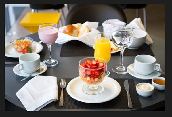 A breakfast setting with a variety of food items and drinks on a table.