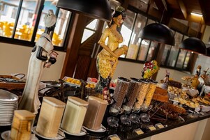 Un bufé con diferentes opciones de comida y una estatua decorativa.