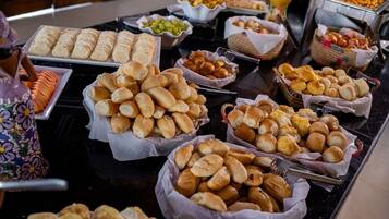 Uma mesa de buffet com diversos produtos de pastelaria e petiscos.