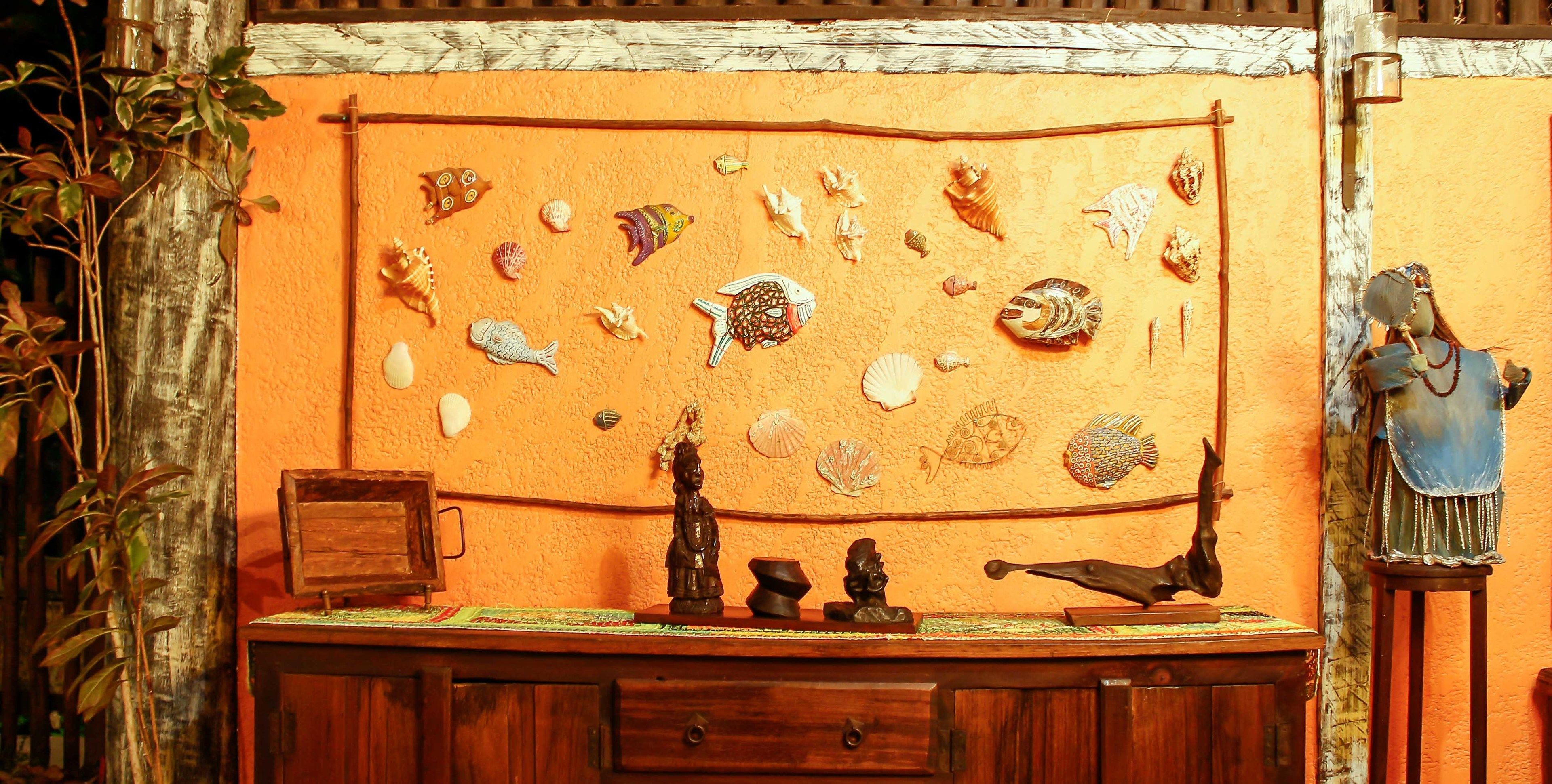 A wooden cabinet with a shelf displaying various decorative items, including shells and figurines.
